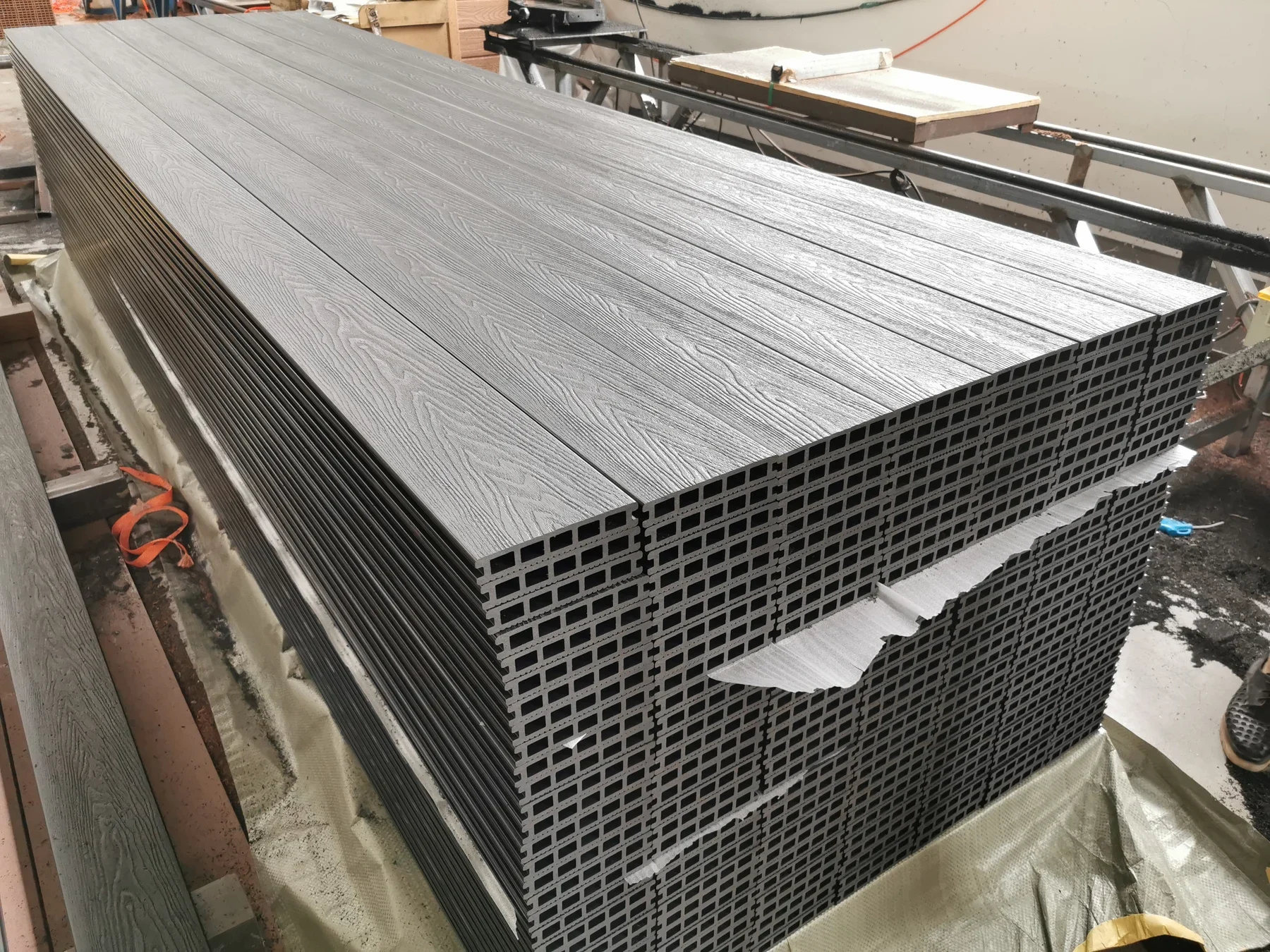 Stacked gray composite boards showing surface texture and hollow profiles