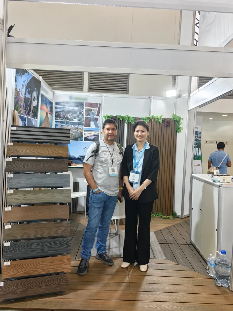 A conversation beside composite board samples at an exhibition stand